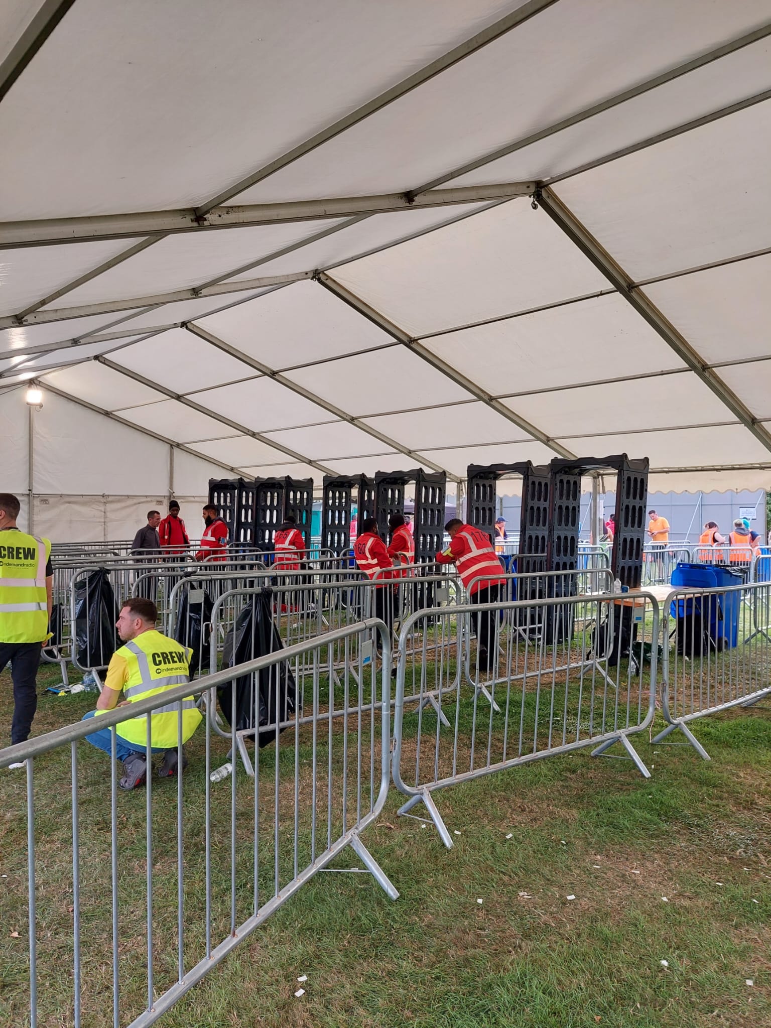 ScanGuardian arches being set up under a large marquee tent at a festival with crew in hi-vis